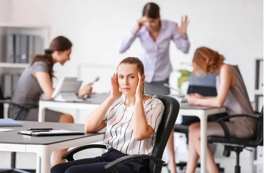 Corporate employee overwhelmed by office noise, thinking how to soundproof an office.