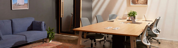Recess stand up desk with ergo chair and small pot plants in corner of screen