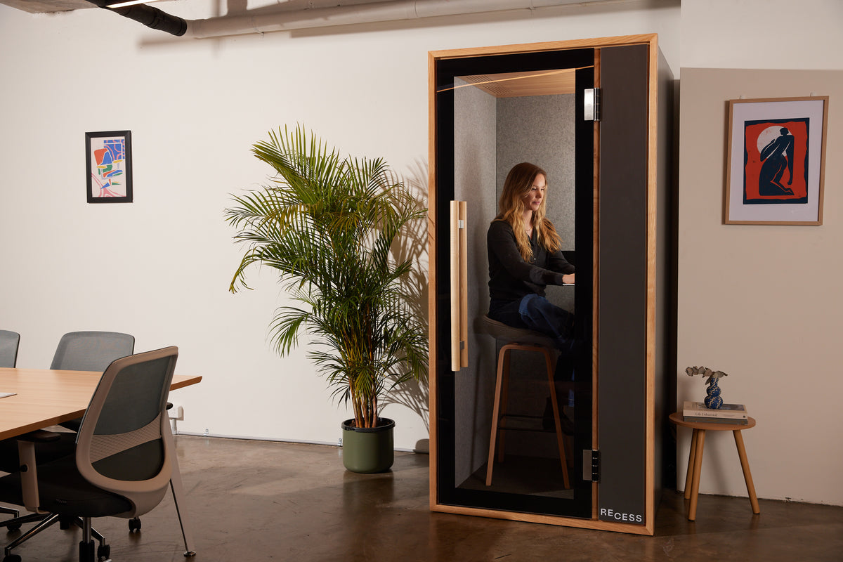 Person working in a Recess soundproof booth with acoustic wall panels